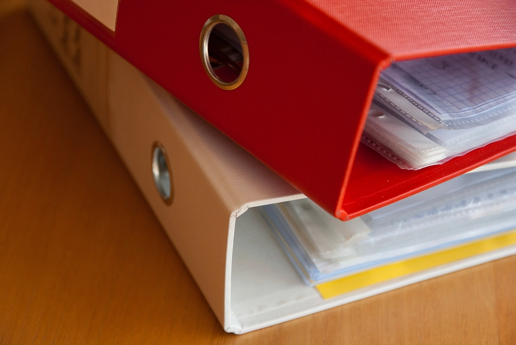 Folders of regulatory filings arranged on an office desk