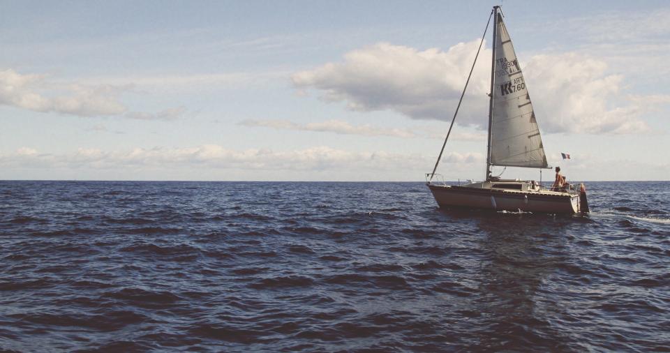Small sailboat on calm water suggesting testing the waters
